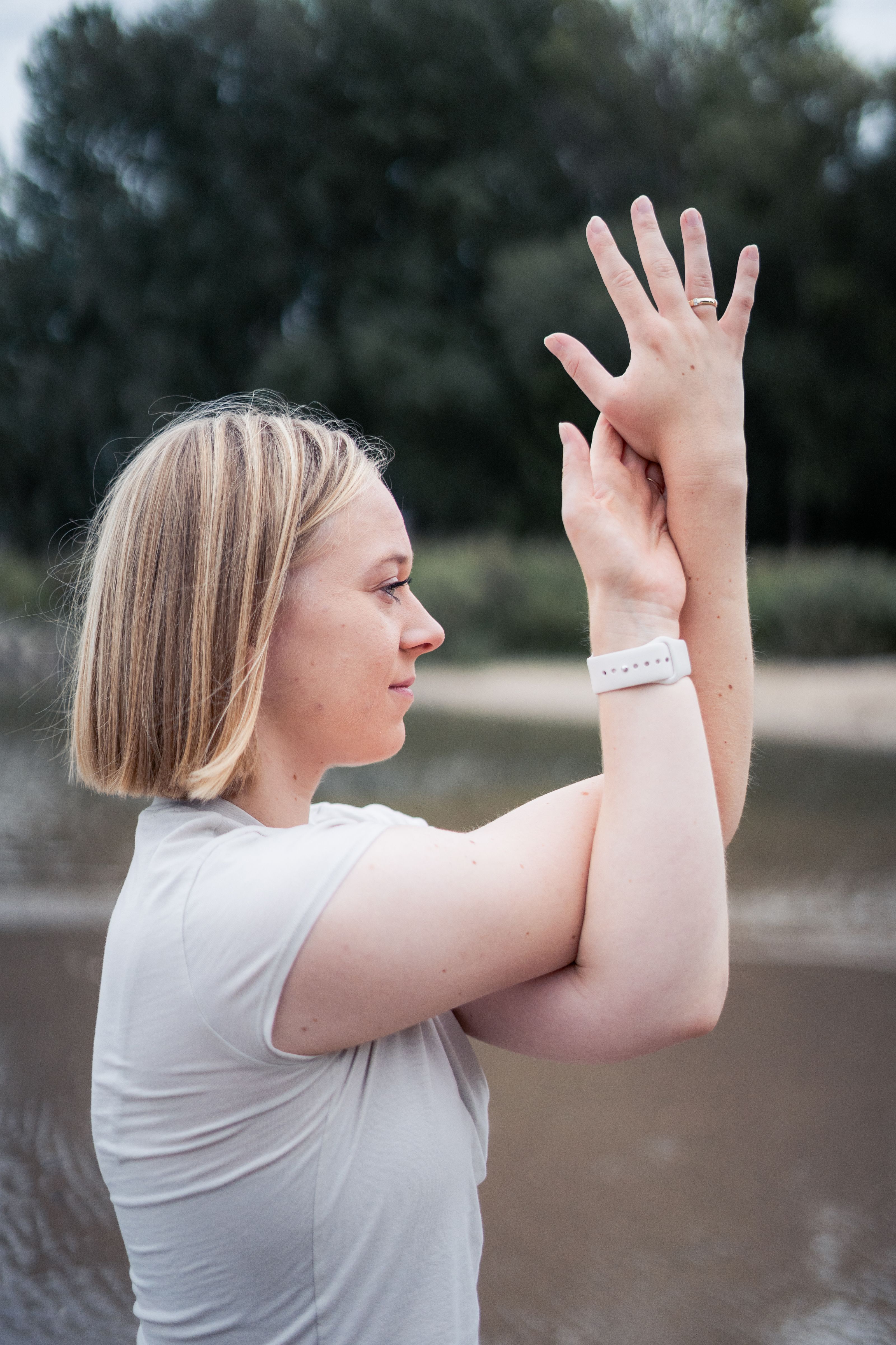Ein Bild von Julia in der Natur, wie sie die Adlerarme eine Yogahaltung einnimmt. 